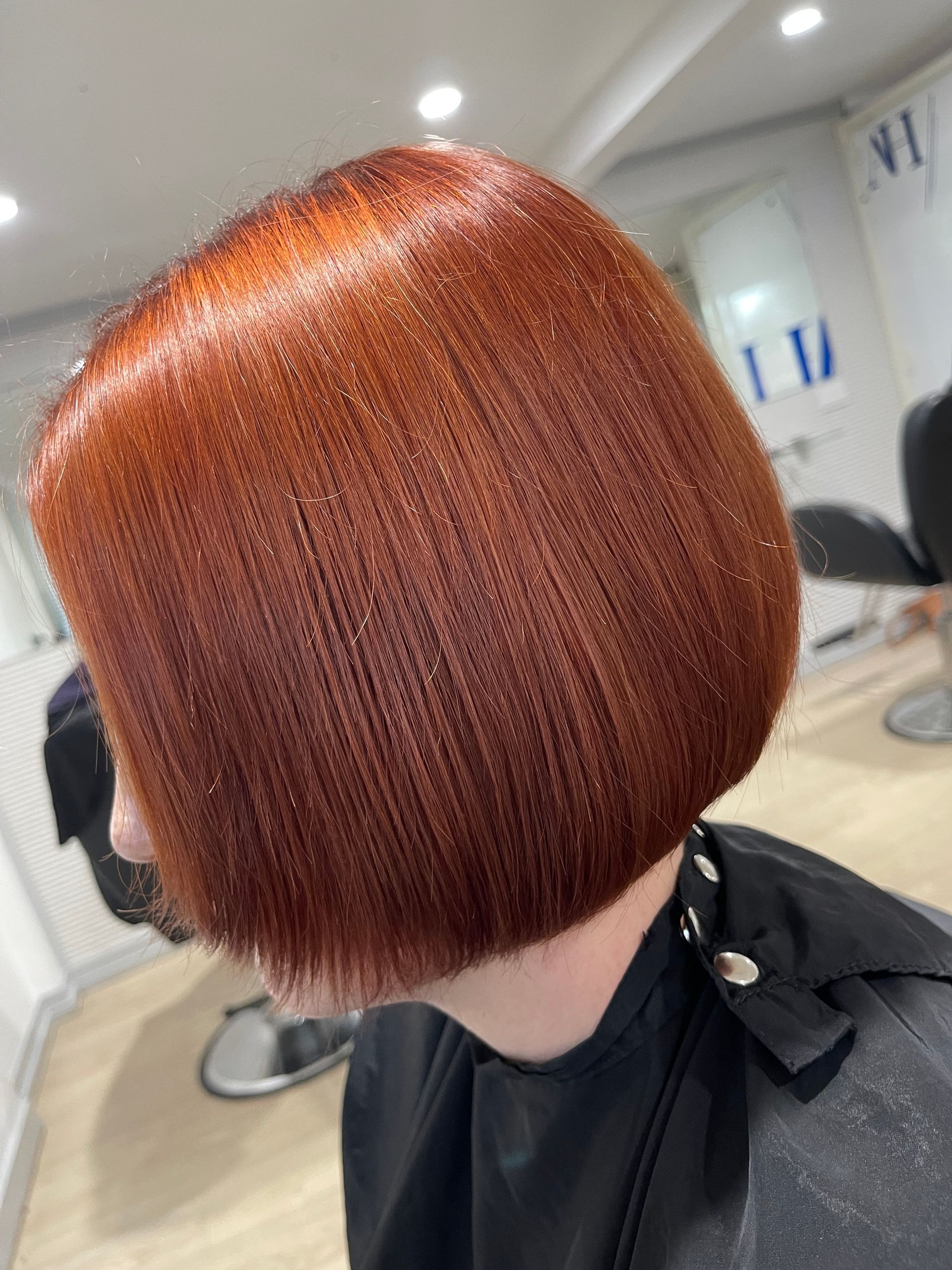 A Woman With Long Red Hair is Sitting in a Chair — Azure Hair in South Mackay, QLD