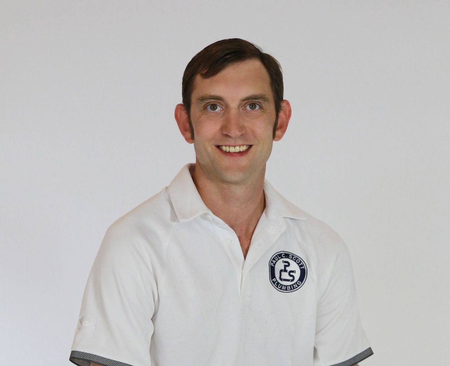 A man wearing a white shirt with a logo on it