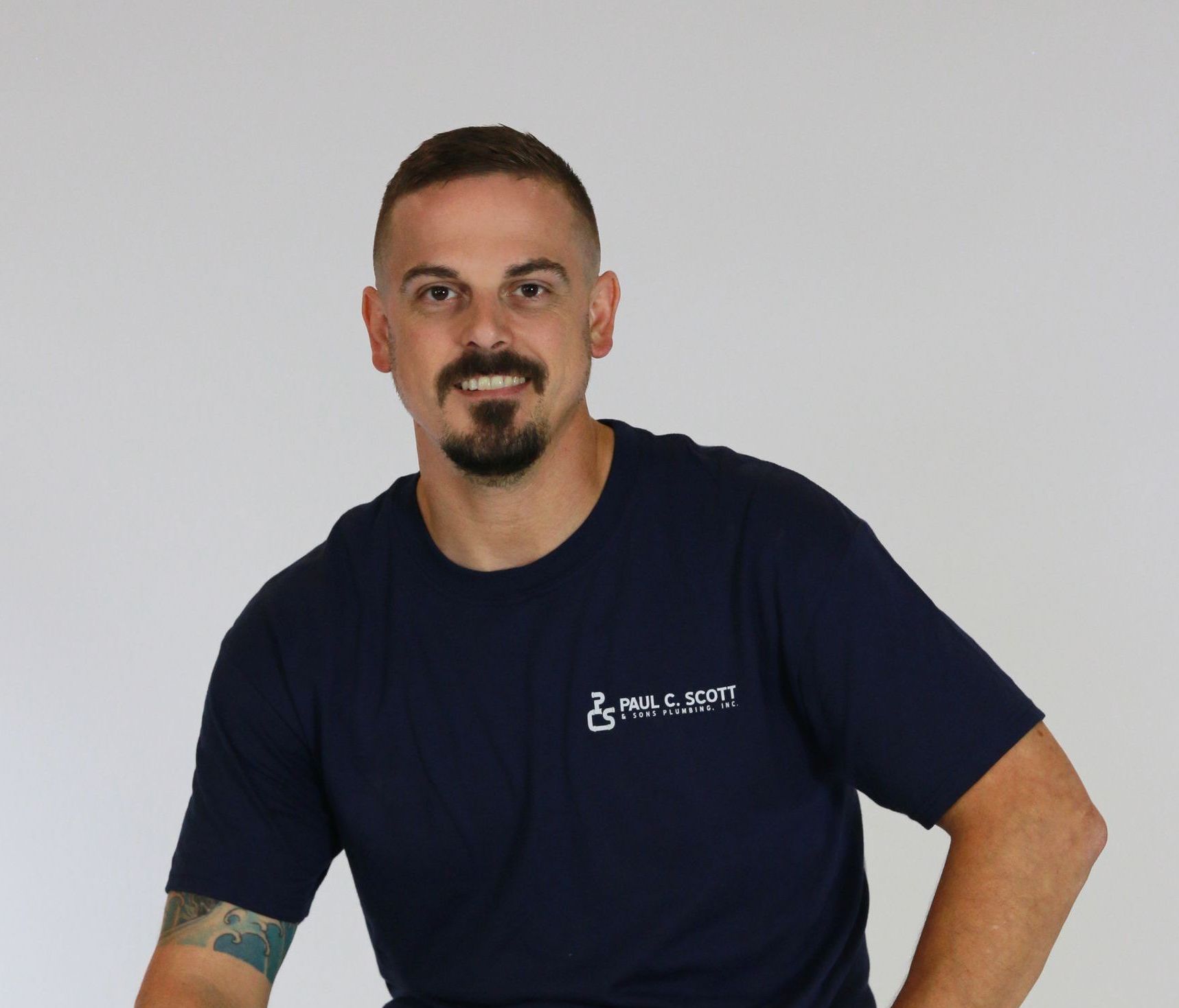 A man with a beard is wearing a blue t-shirt with the word liberty on it