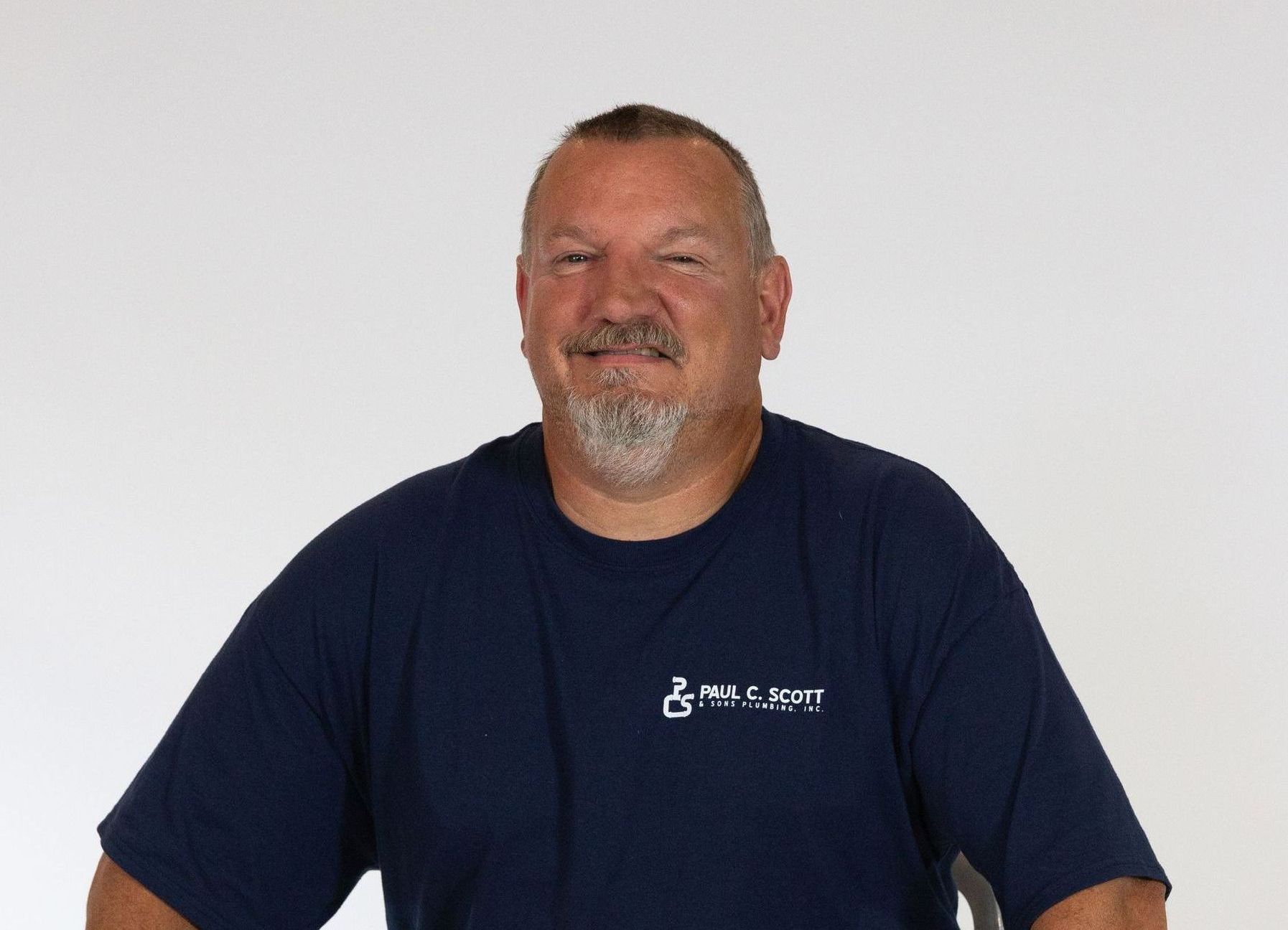 A man with a beard wearing a blue t-shirt with a handicap symbol on it