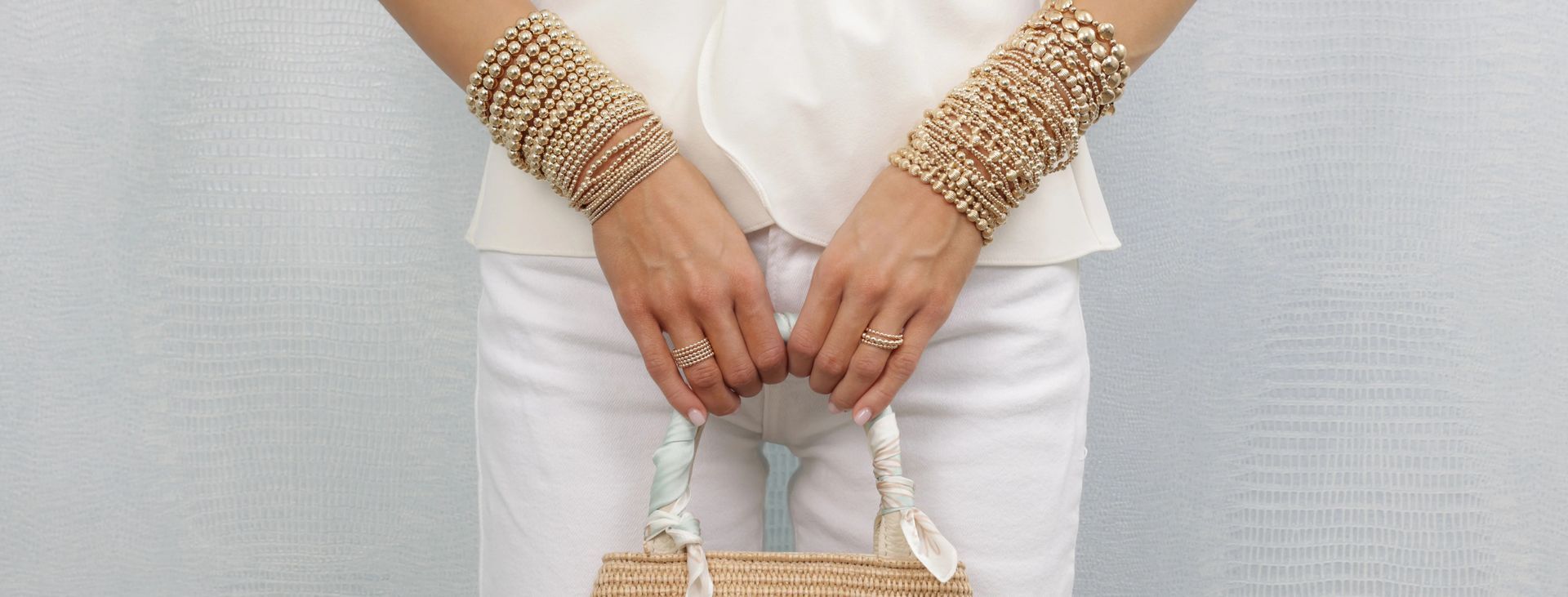 Woman wearing silver bracelets and rings on a black dress.