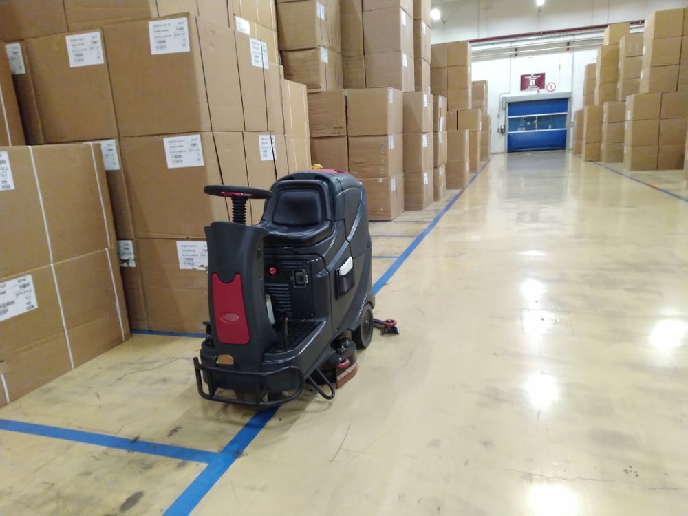 A machine is sitting in the middle of a warehouse filled with boxes.