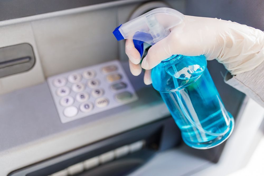 A person is cleaning a printer with a spray bottle.