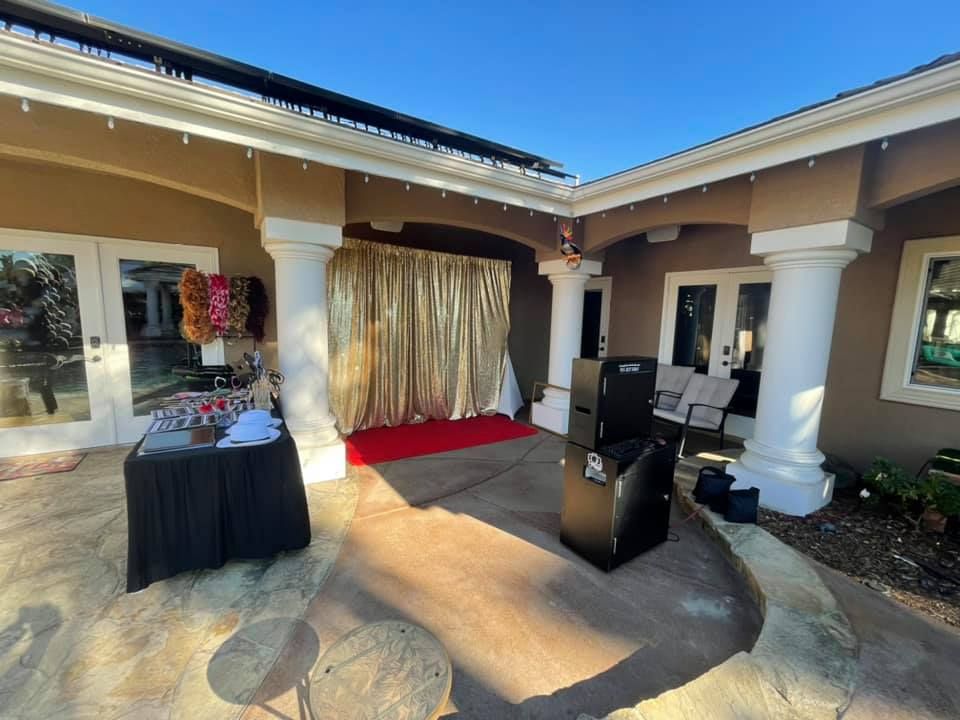 Outdoor party setup with gold curtain backdrop, red carpet, and sound equipment.