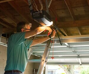 Garage Door Installation — Man Drilling Upper Garage in Chesapeake, VA