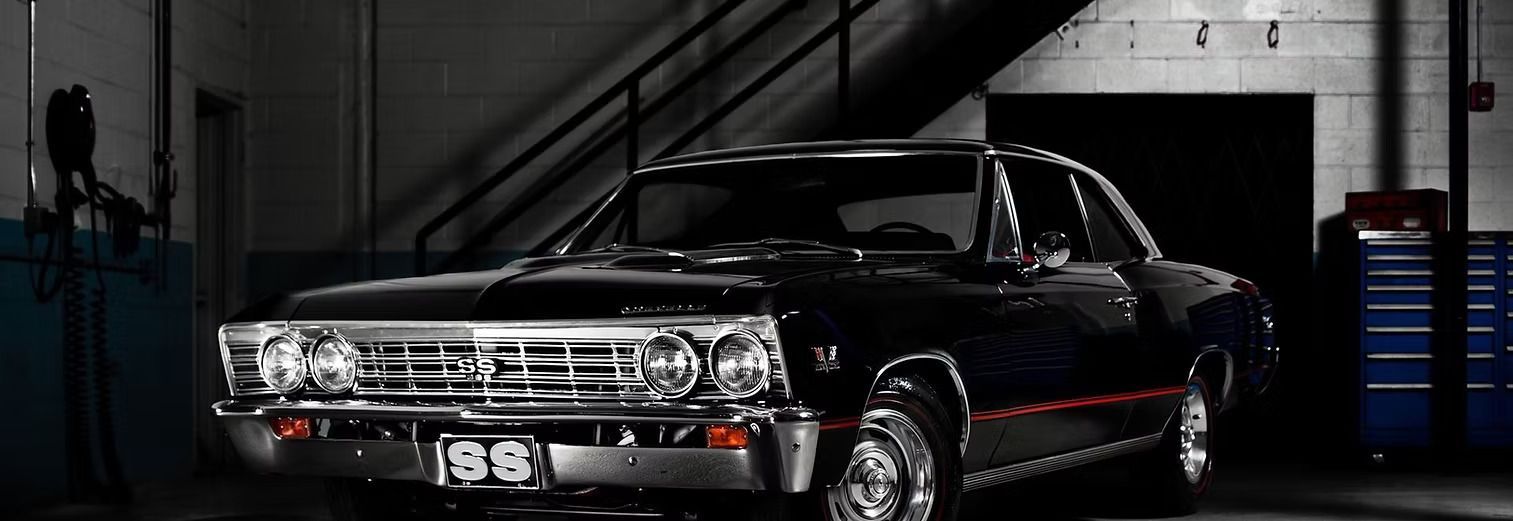 Black classic car parked inside a garage.