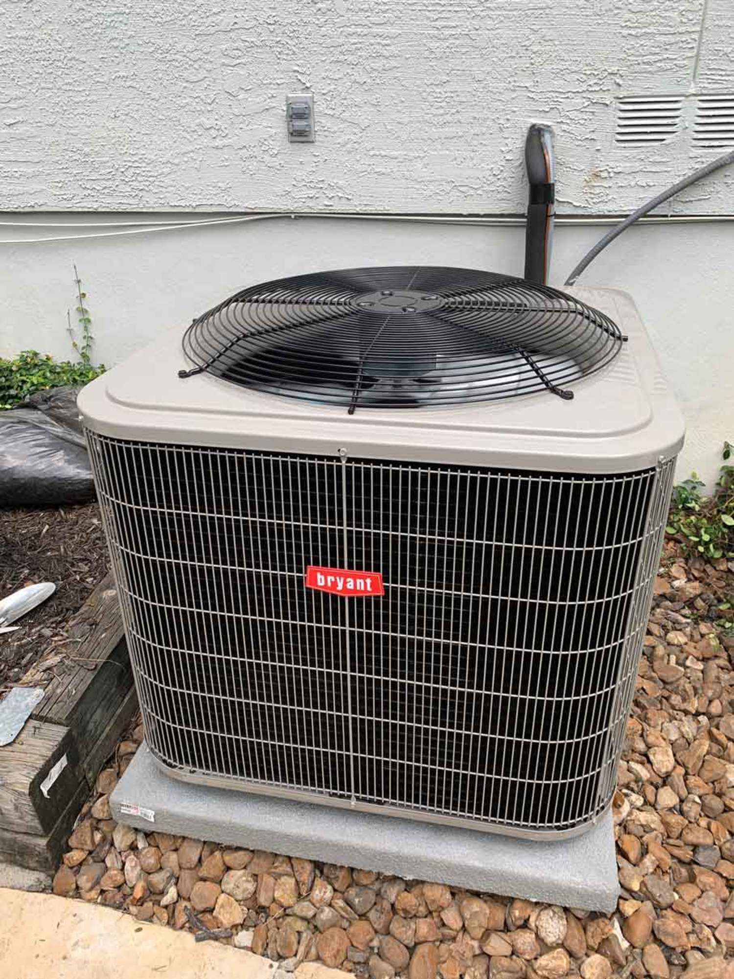 a large air conditioner is sitting on top of a pile of rocks .