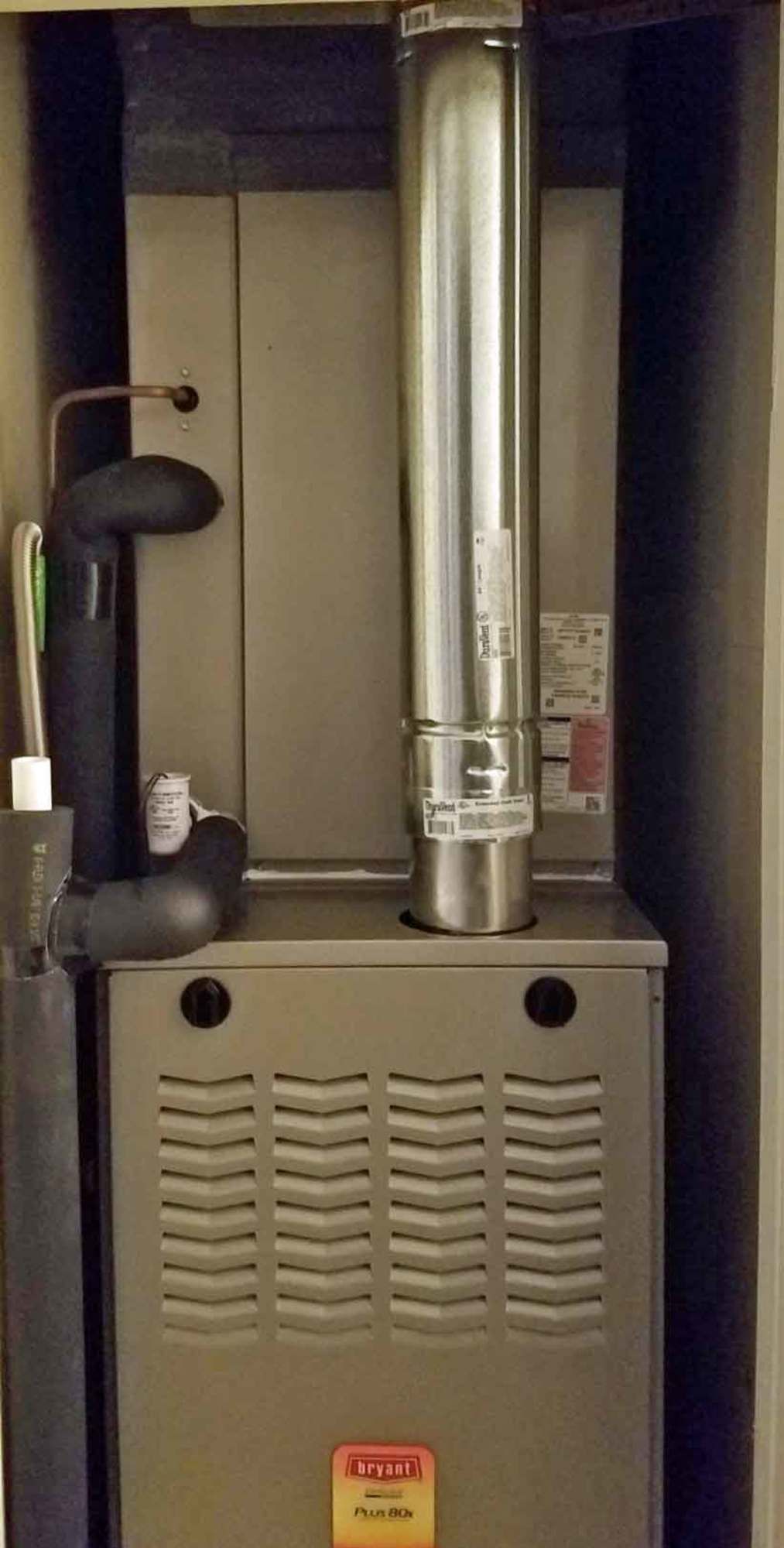 a furnace is sitting in a closet next to a chimney .