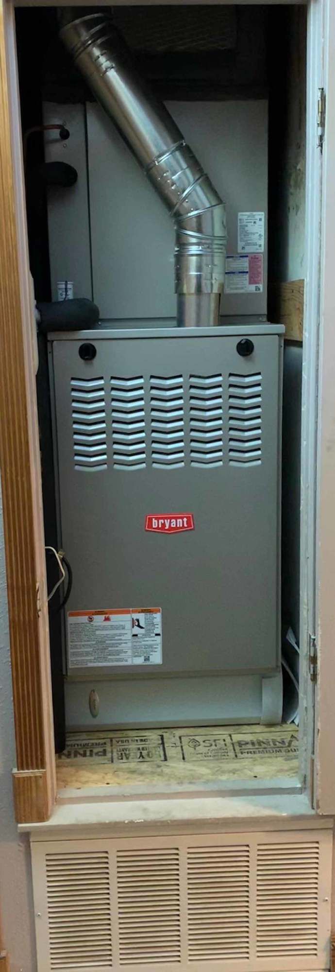 a furnace is sitting inside of a cabinet in a room .