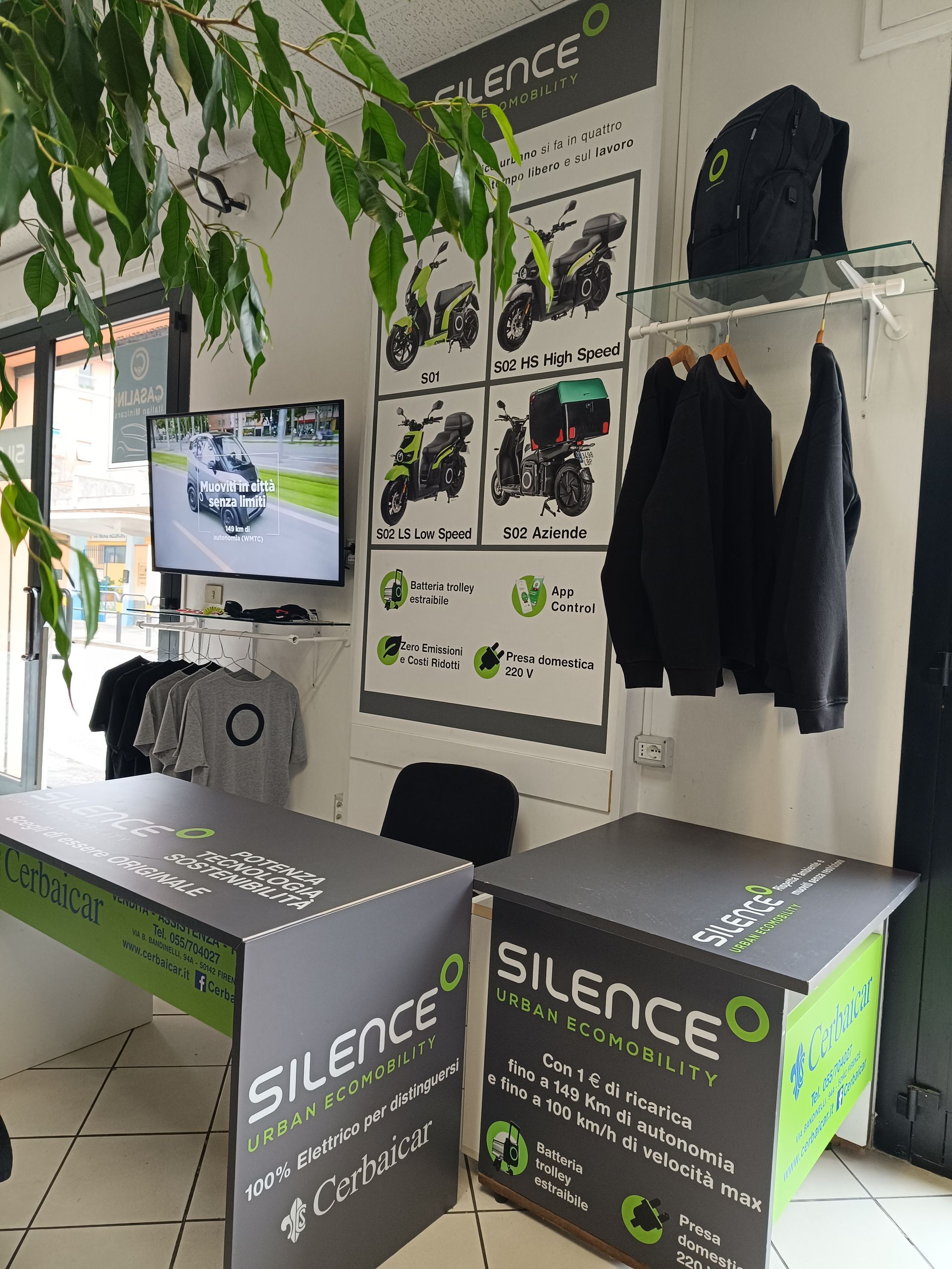 Una stanza con due tavoli e una tv a parete.