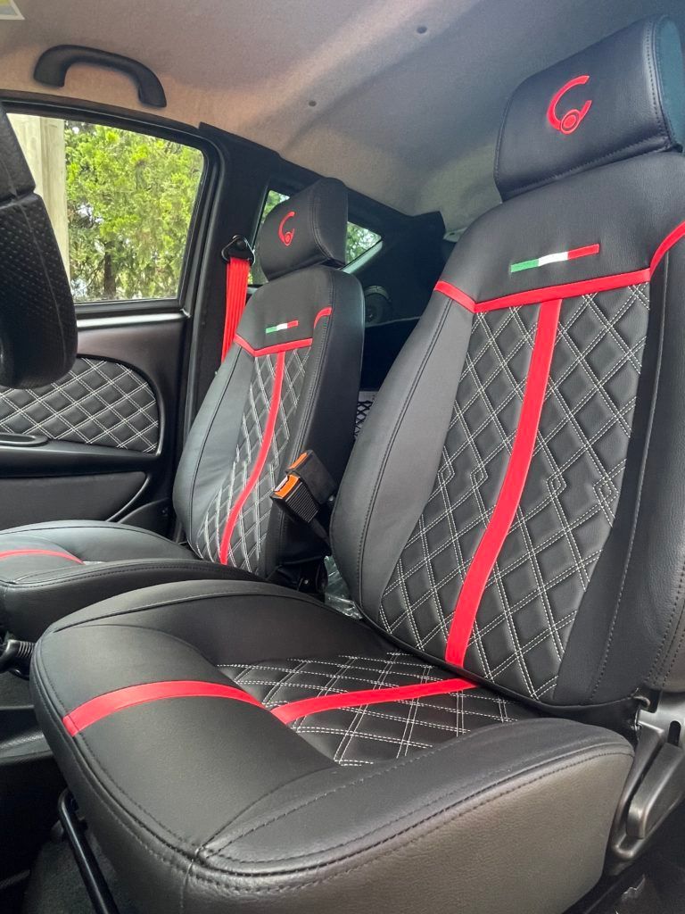 L'interno di un'auto con sedili neri e rossi.