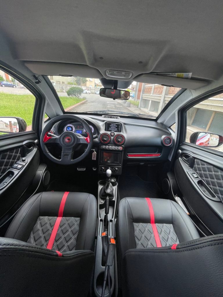 L'interno di una piccola automobile con strisce rosse sui sedili.