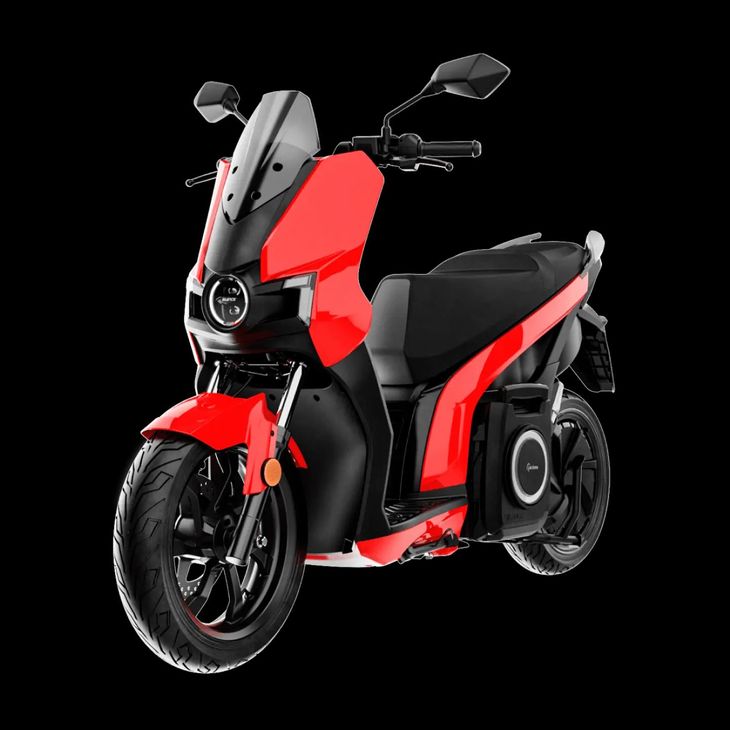 Uno scooter rosso e nero con un altoparlante attaccato su uno sfondo nero.