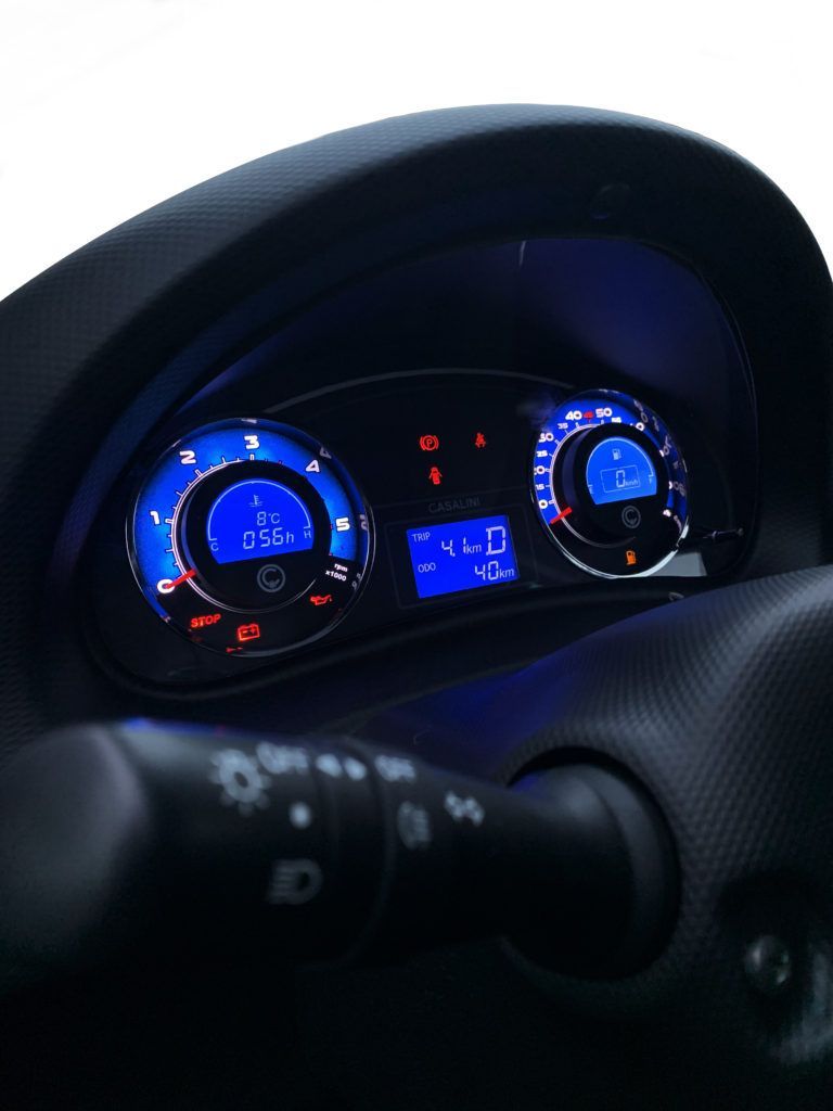 Un primo piano del cruscotto di un'auto con un display blu