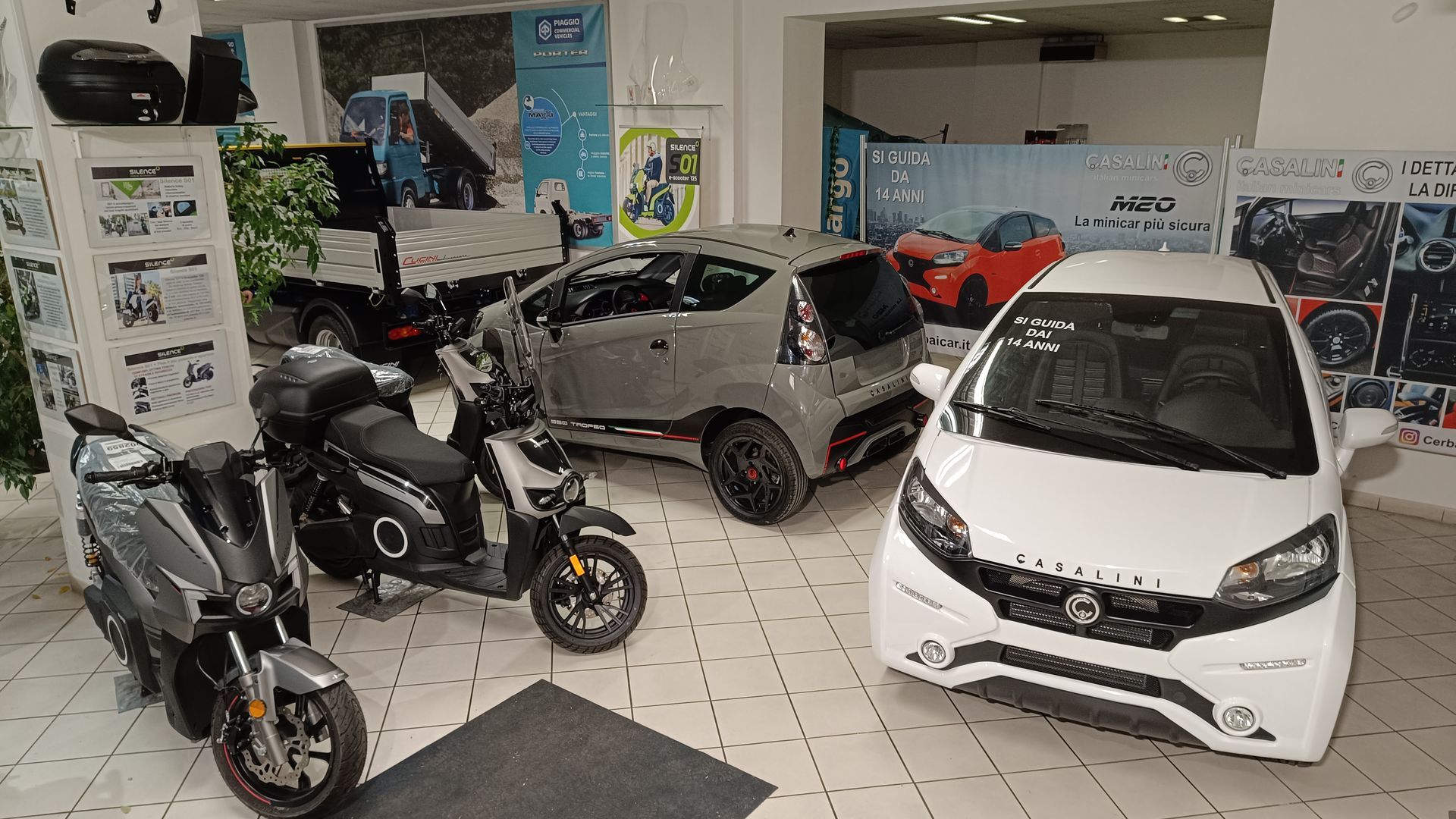 Uno showroom pieno di auto, scooter e motociclette.