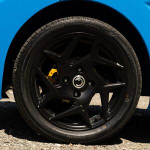 Un'auto blu con cerchio e pneumatico neri