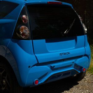 Un'auto blu è parcheggiata su una strada sterrata