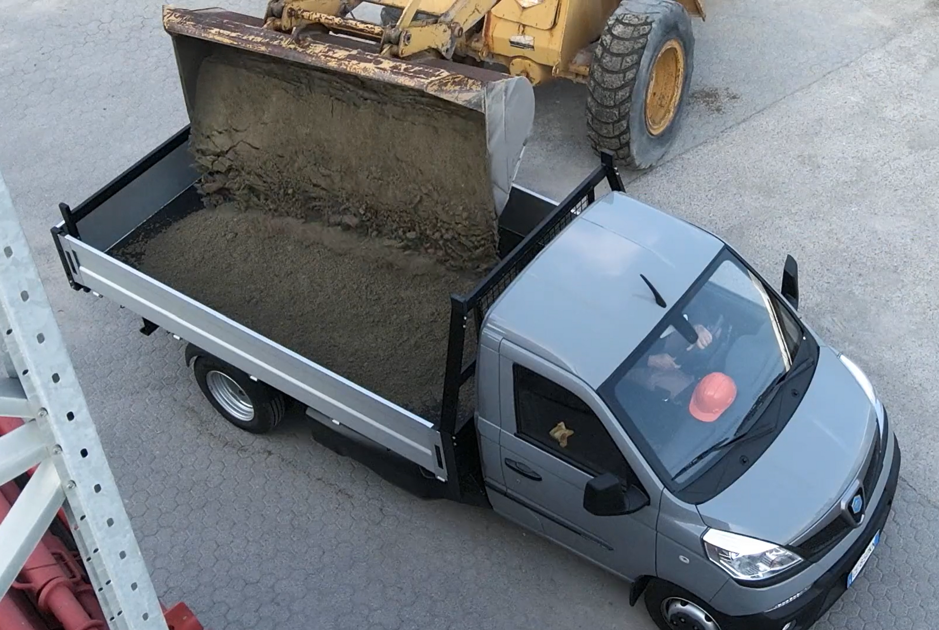 Un camion viene caricato di terra da una ruspa