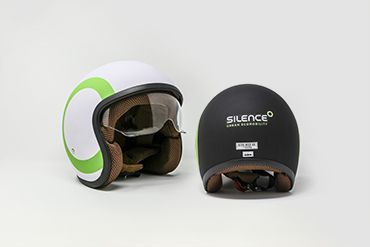 Due caschi sono appoggiati uno accanto all'altro su una superficie bianca.