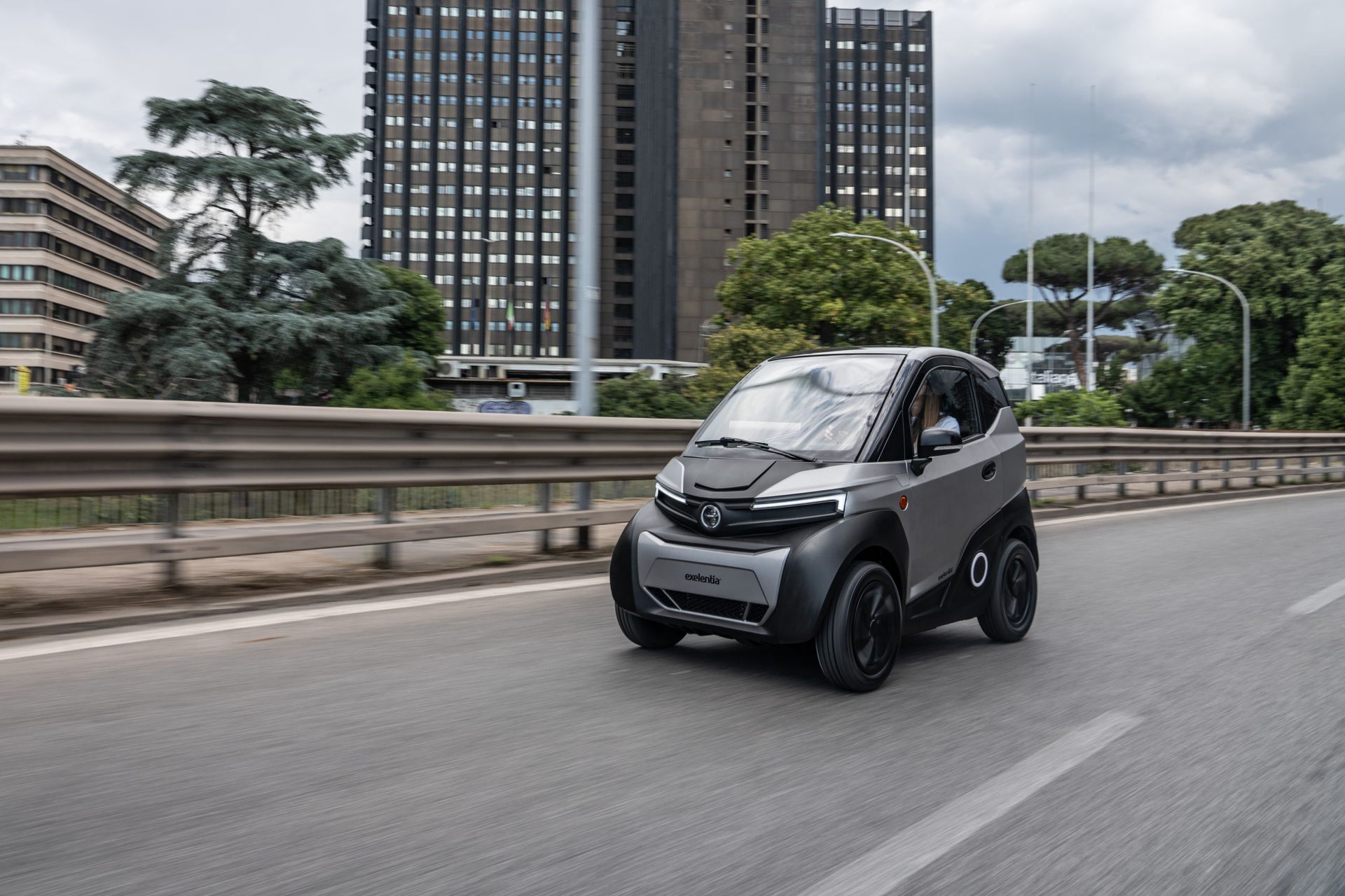 Una piccola auto elettrica sta percorrendo un'autostrada in città.