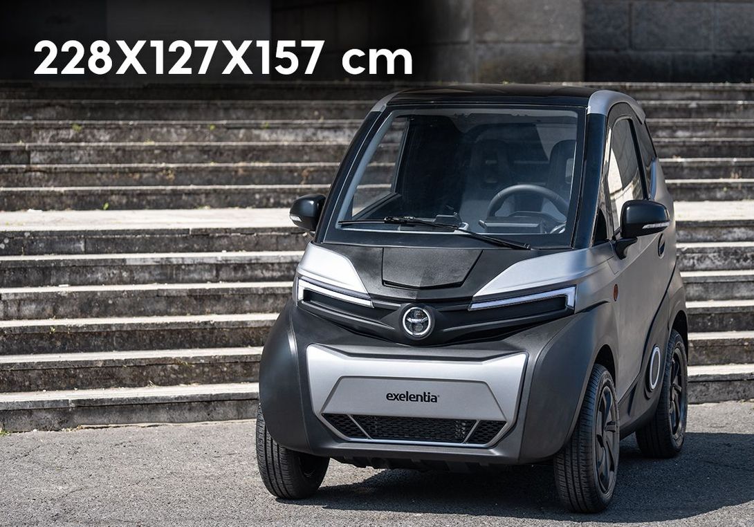 Una piccola automobile è parcheggiata davanti a una rampa di scale.