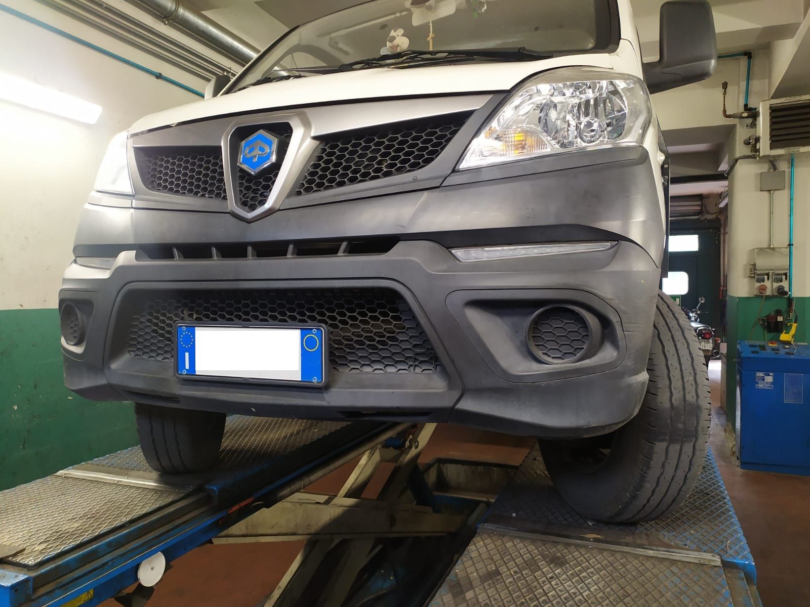 Un furgone bianco è parcheggiato su un ascensore in un garage.