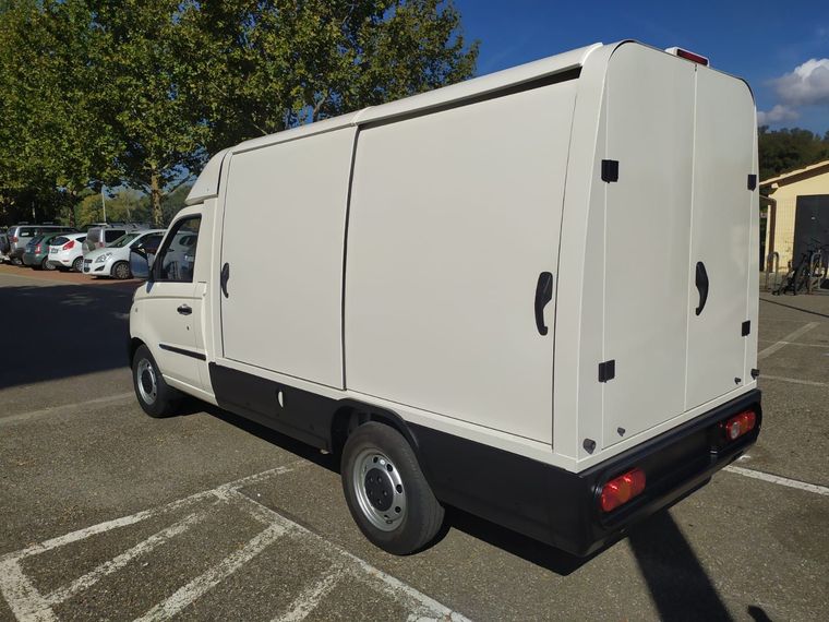 Un furgone bianco è parcheggiato in un parcheggio.