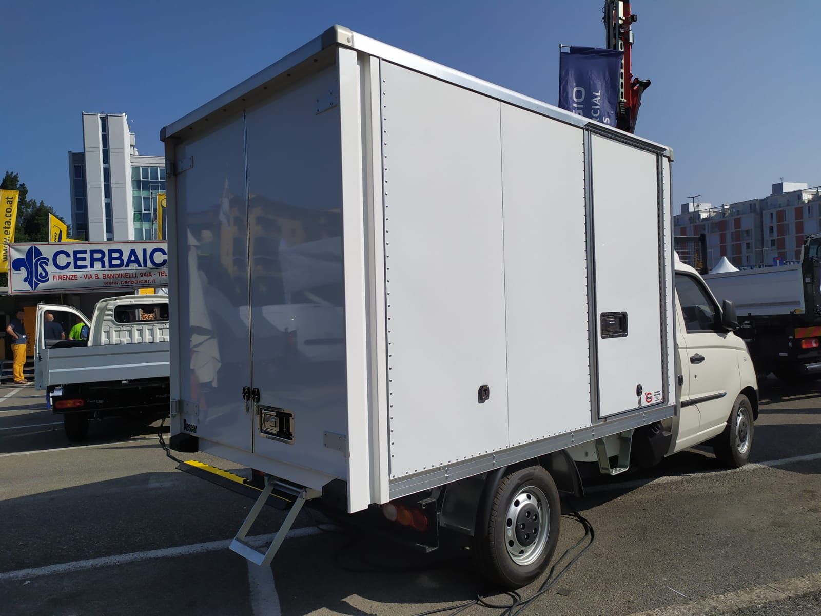 Un camion bianco è parcheggiato davanti a un cartello sconcertante