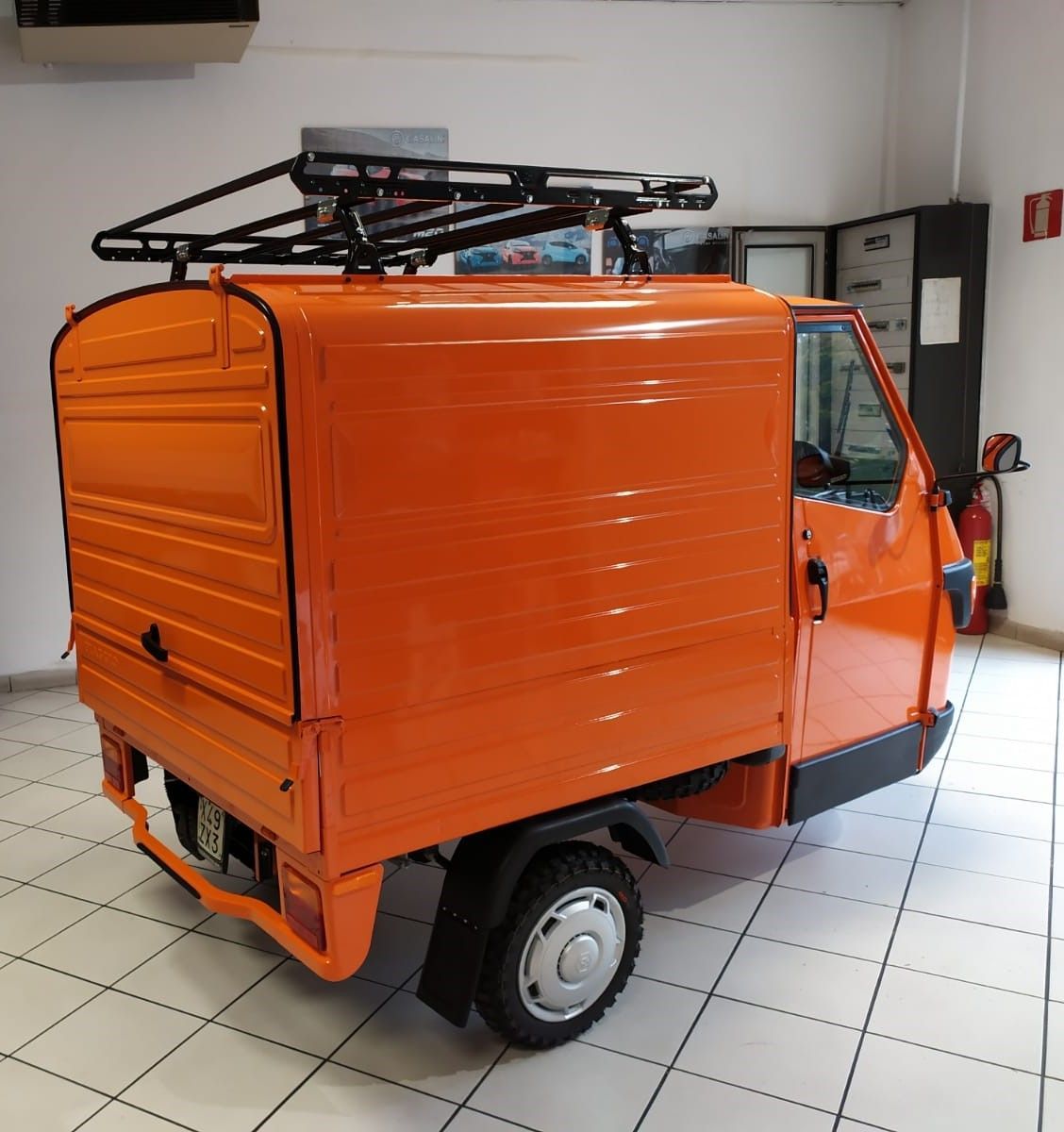Un furgone arancione con un portapacchi è parcheggiato in una stanza