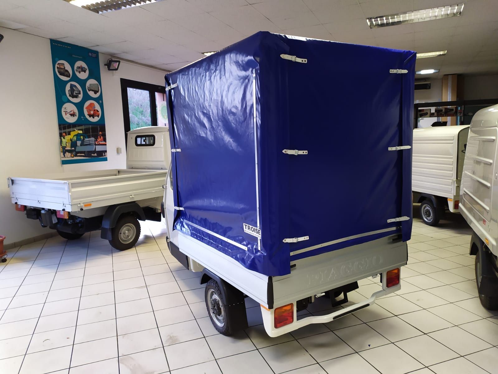 Uno scooter con una capottina blu è parcheggiato in un garage.