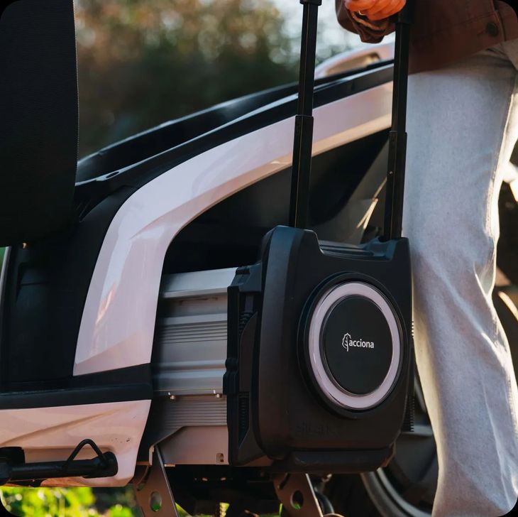 Una persona è in piedi accanto a uno scooter con un altoparlante attaccato