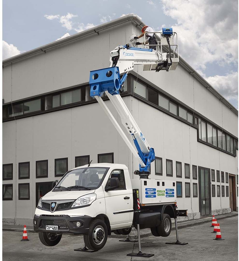 Un camion con una gru sopra è parcheggiato davanti a un edificio.