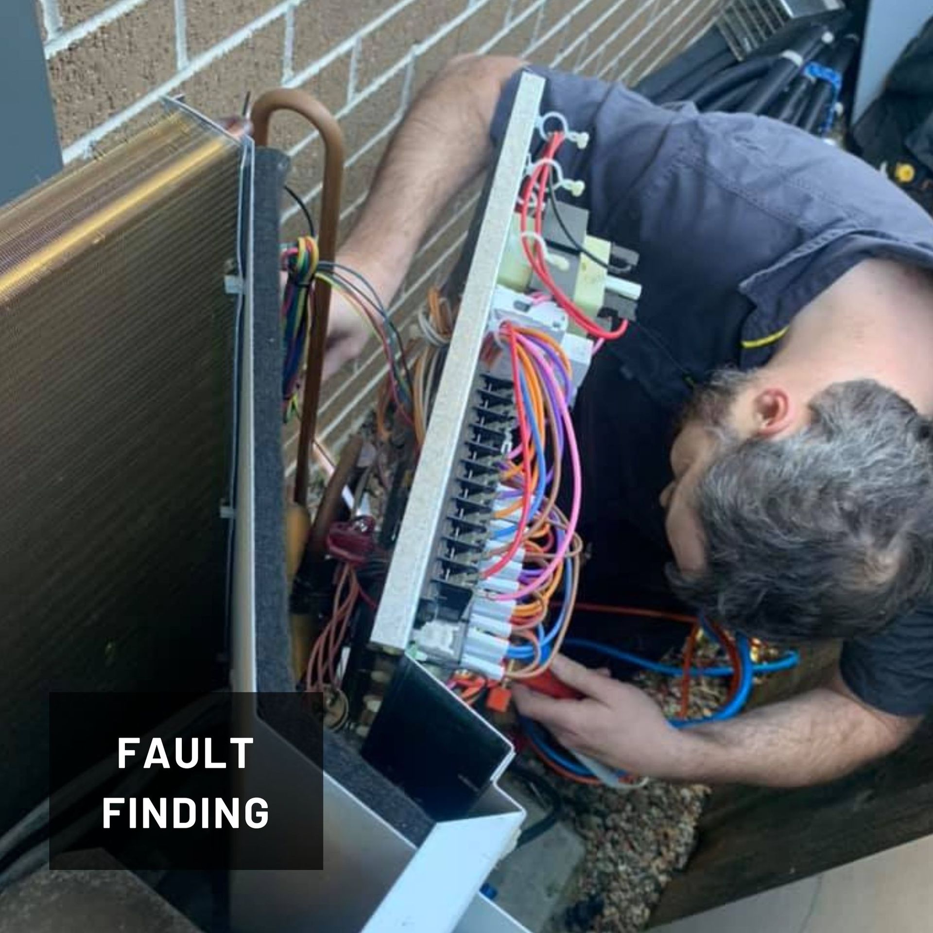 A Man Is Working on An Air Conditioner — Revive Air Conditioning in Campbelltown, NSW