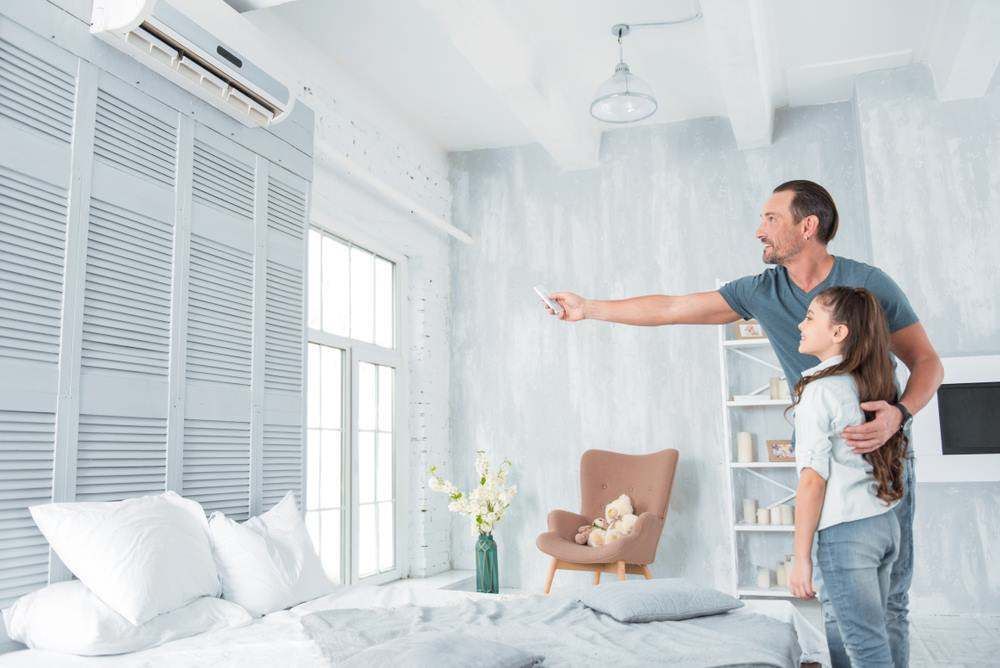 A Man and Child, Smiling, Adjust an Air Conditioner in a Bright in Campbelltown