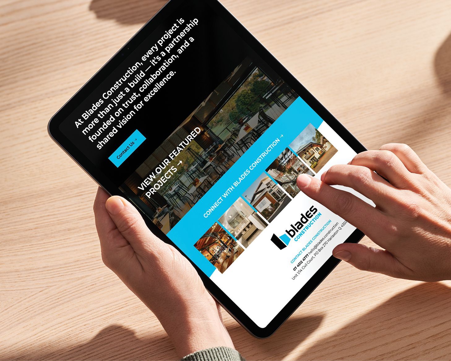 Hands using a tablet displaying a travel website with blue and white sections