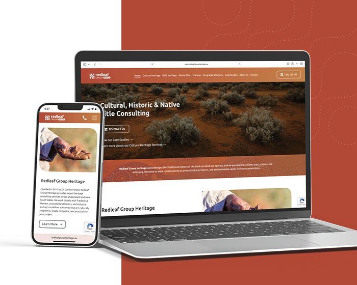 Laptop and phone displaying a consulting website with an orange header and desert hero image