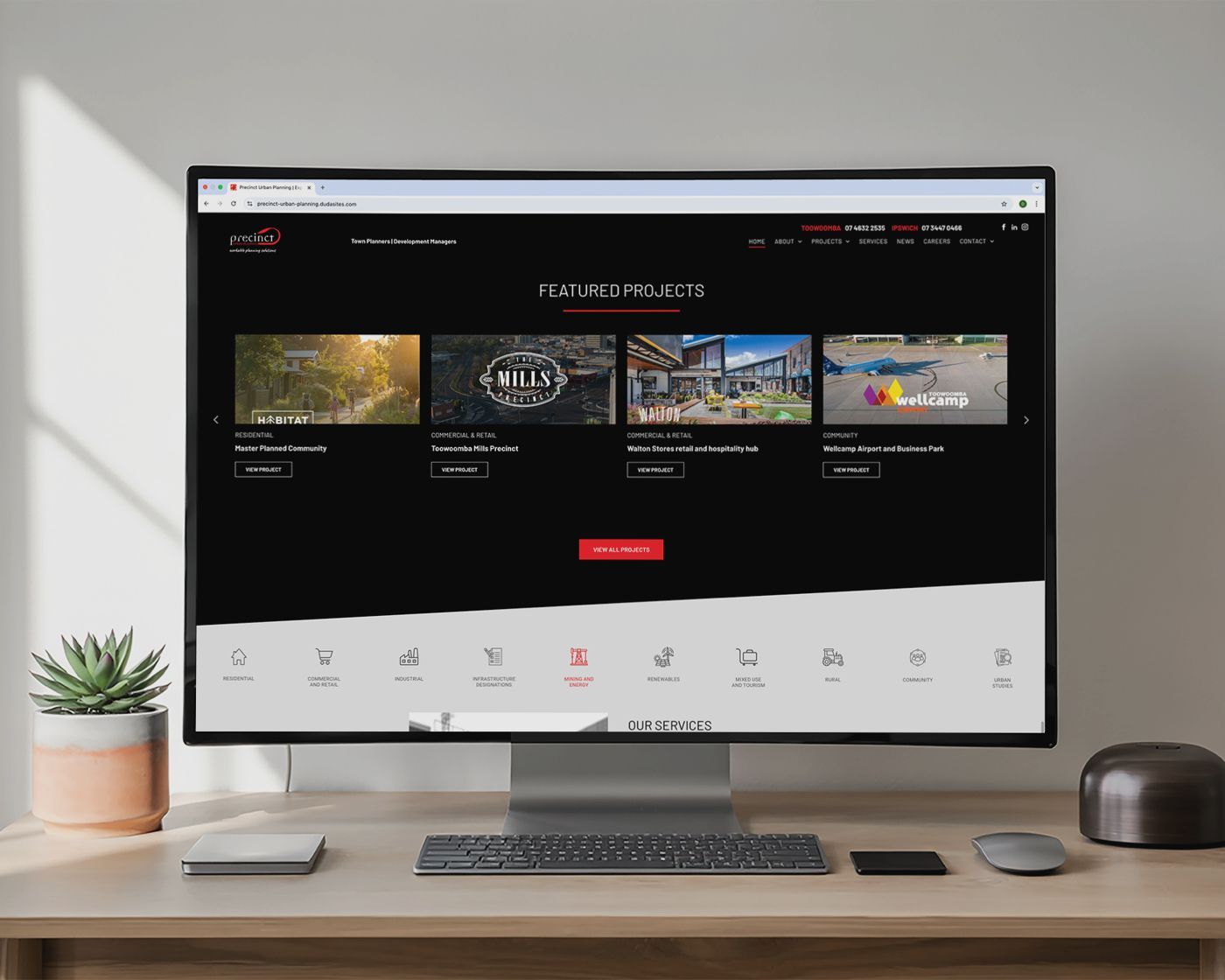 Desktop computer on a wooden desk displaying a streaming website with movie thumbnails on a dark screen