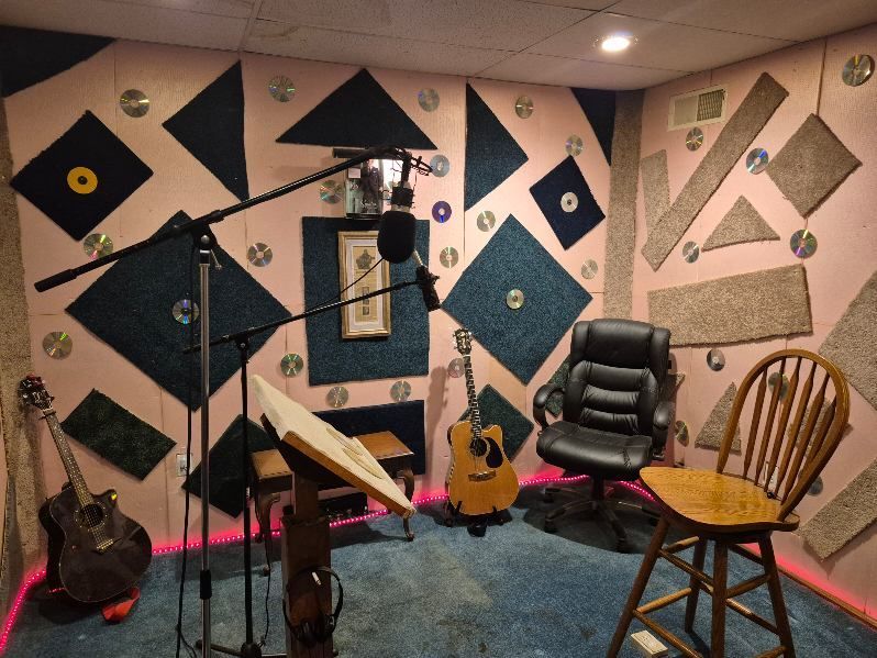 A recording studio with guitars and a microphone