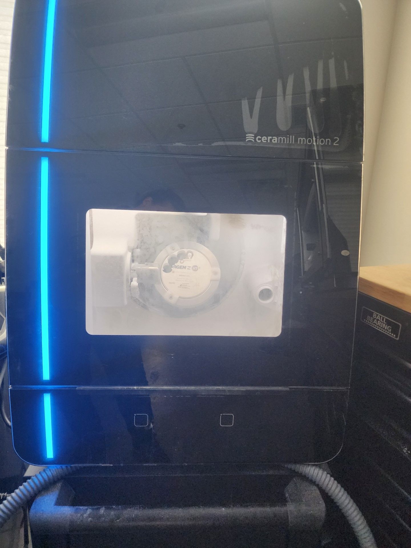 a black machine with a blue light on it is sitting on a table 