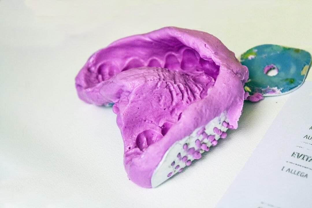 A close up of a purple dental impression on a table.