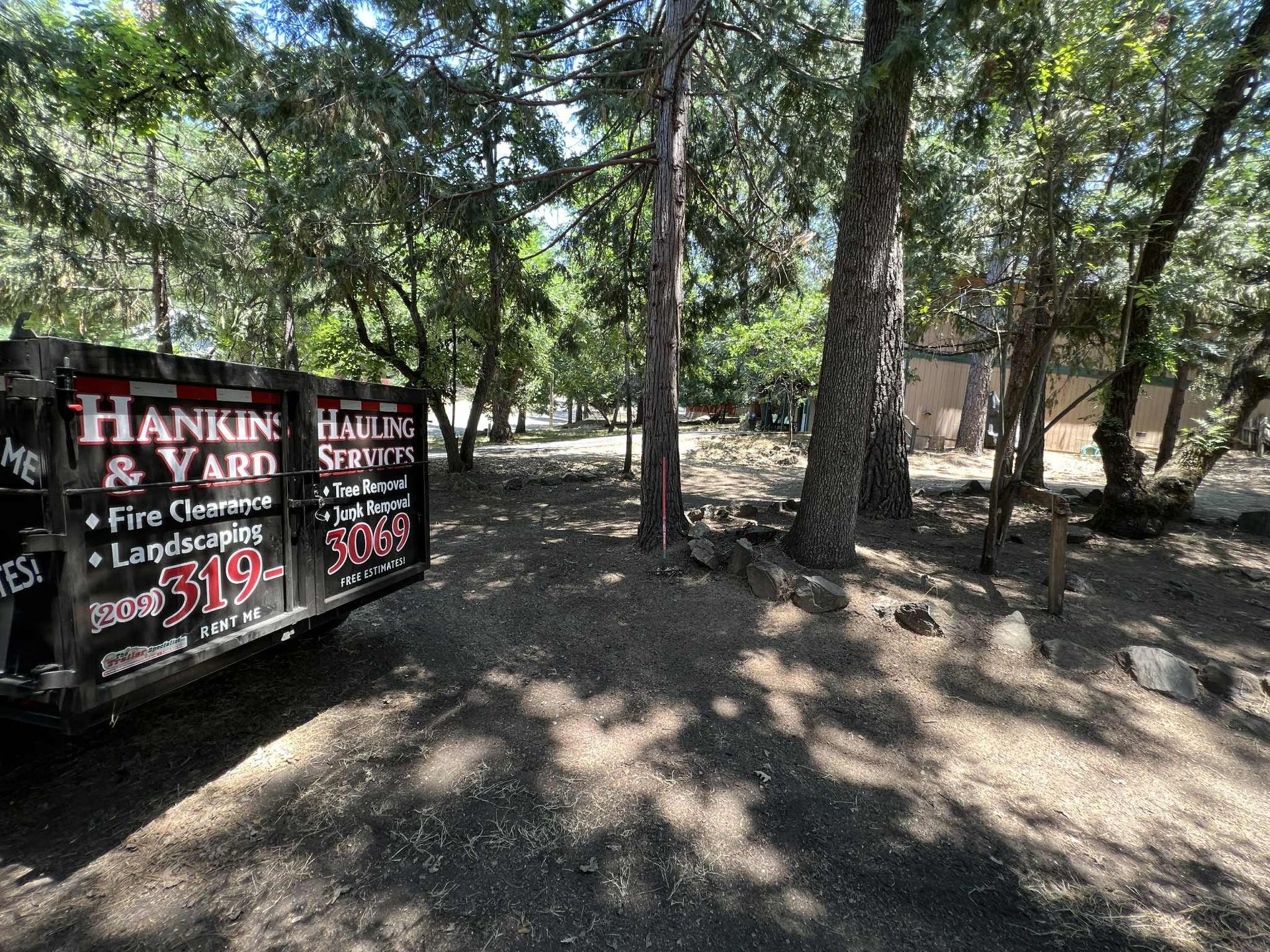Dumpster for Hankin & Yard fire clearance and landscaping in a wooded area.