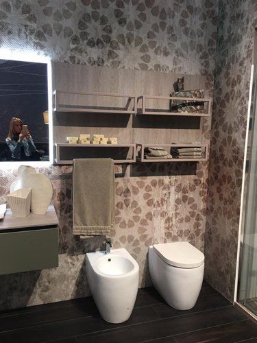 bagno moderno con bidè e riflessa di una donna in specchio