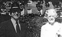 A man and a woman are standing next to each other in a black and white photo.