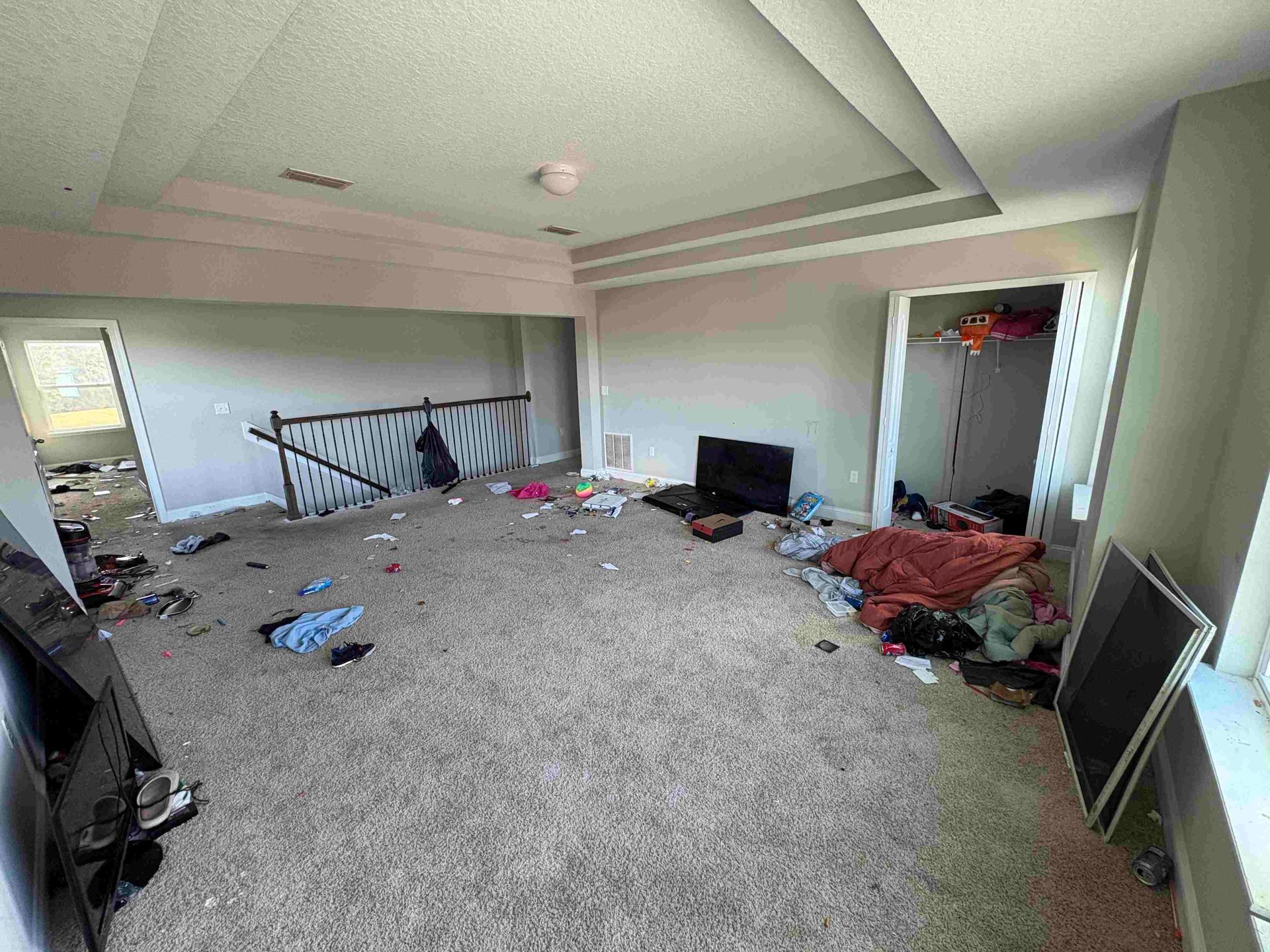 Messy room with scattered debris, clothing, and a damaged railing.
