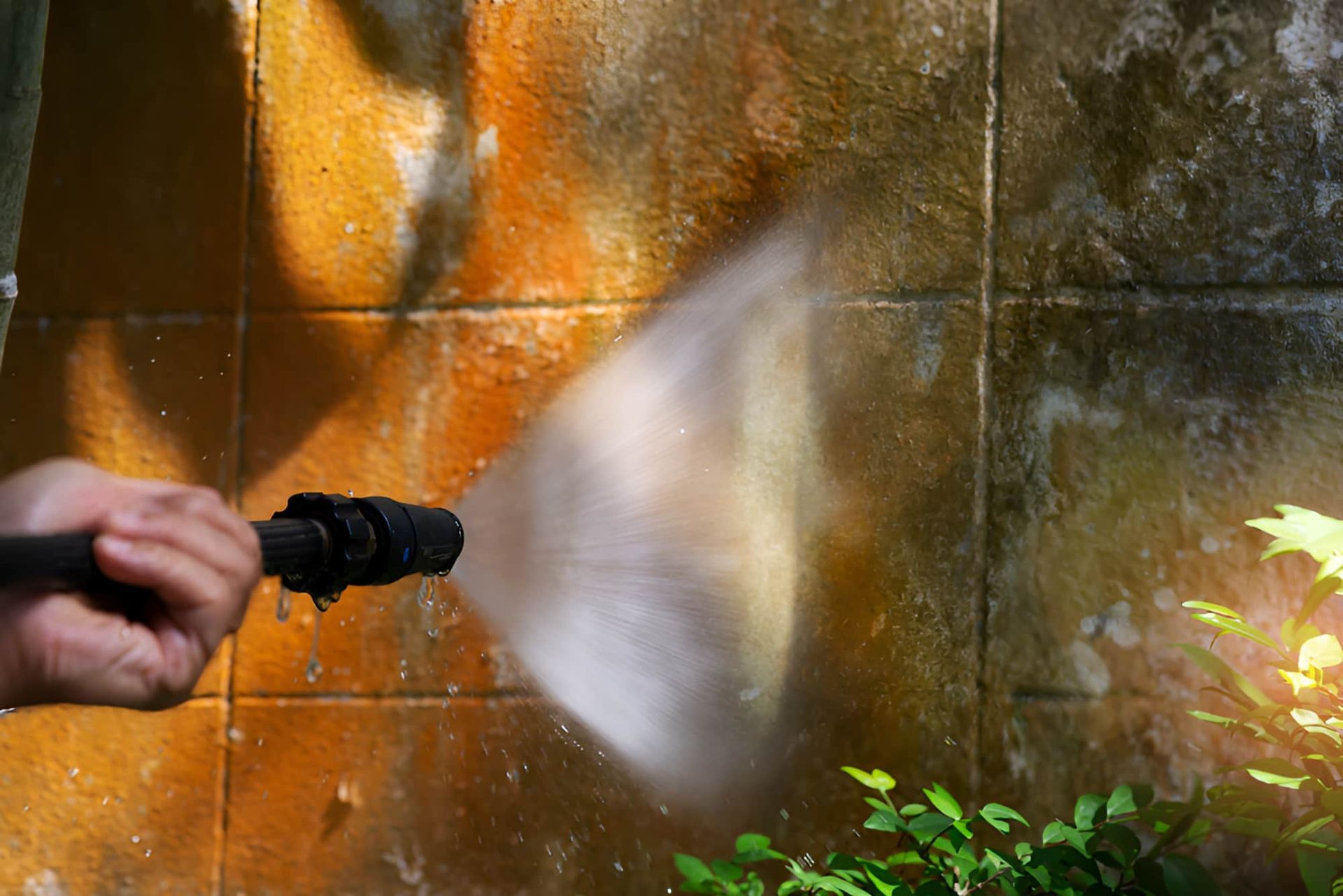 A Person is Using a High Pressure Washer to Clean a Wall — First Choice Cleaning Services in Wodonga, VIC