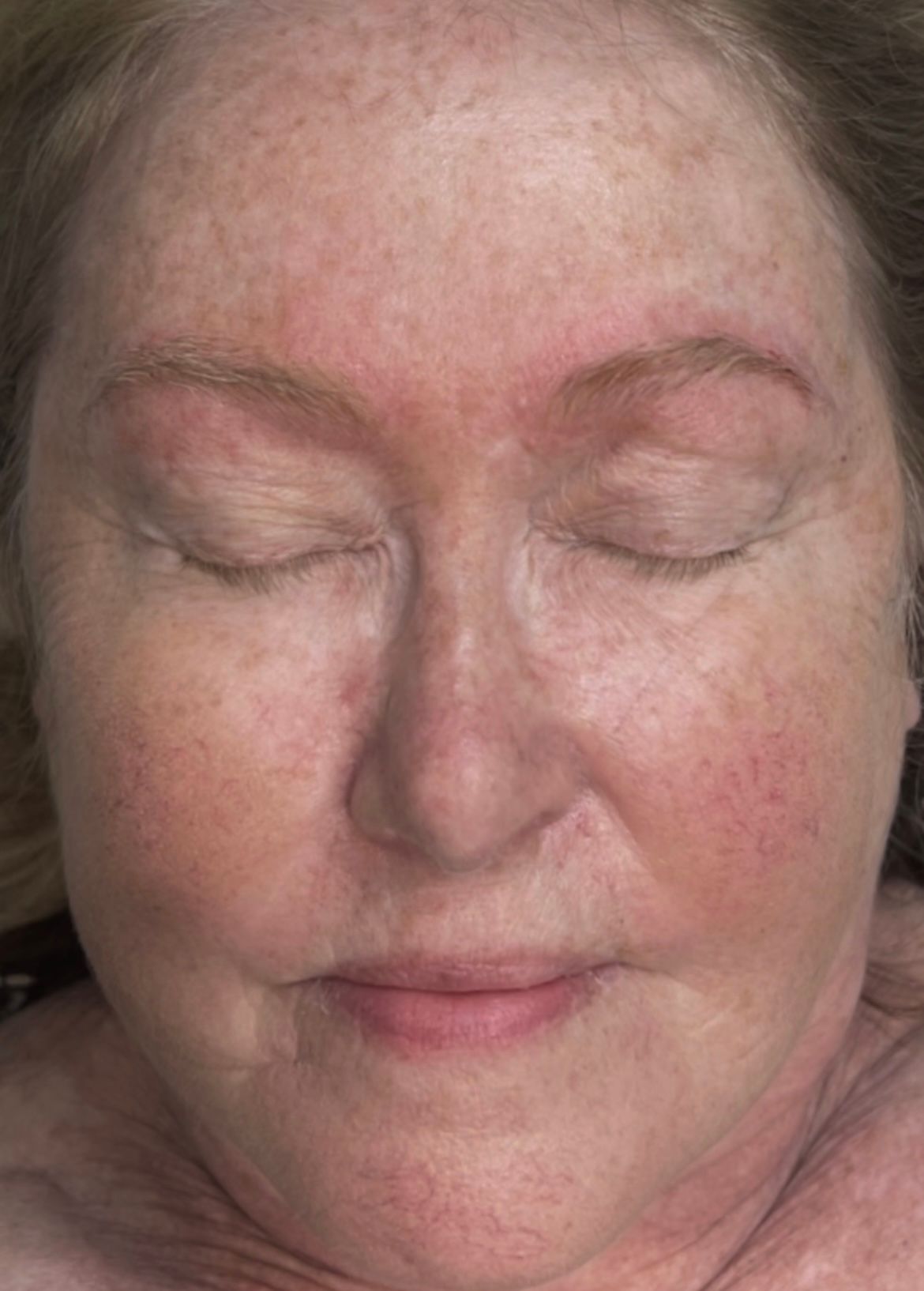 A close up of a woman 's face with her eyes closed.