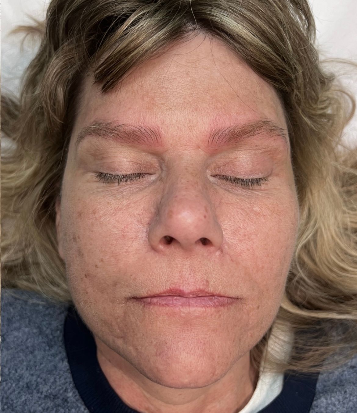 A close up of a woman 's face with her eyes closed.