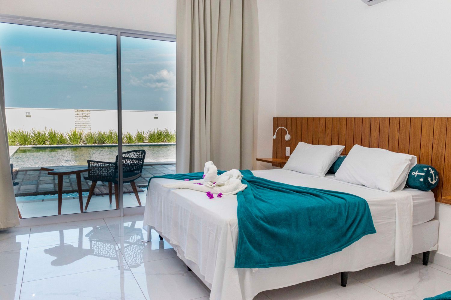 Um quarto de hotel com uma cama grande e uma porta de vidro deslizante.