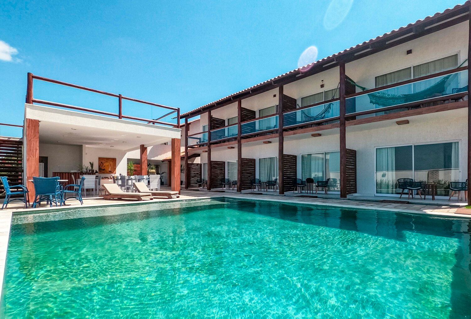 Há uma grande piscina em frente a um hotel.