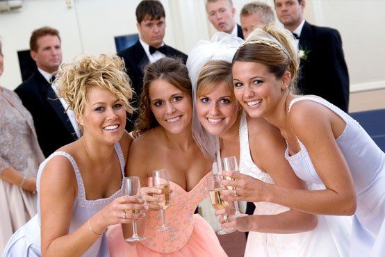 Bride and bridesmaids holding glasses of champagne